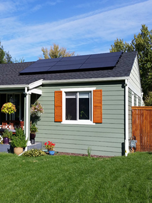 small grey house with all black rooftop solar panels