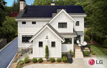 black lg solar panels on the roof of a white house in a wooded aread