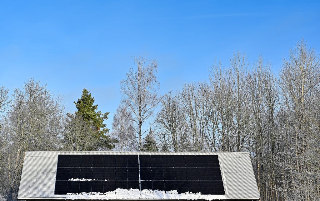 Solar panels on roof in winter with snow atop them